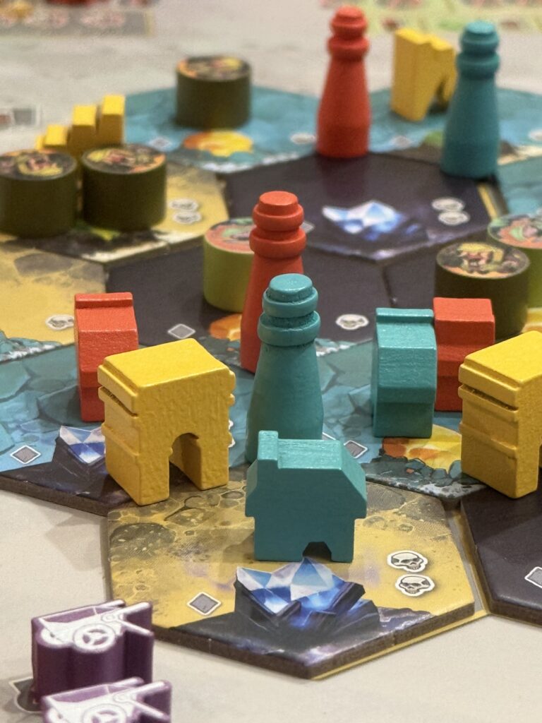 Pions et bâtiments en bois sur le plateau du jeu Covenant.